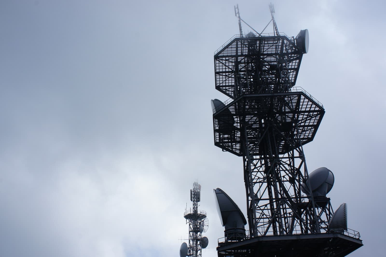 Telecom antenna masts against an overcast sky
